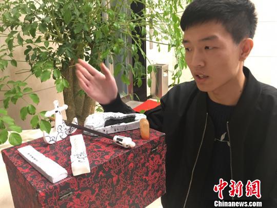 福建省商学院大学生李星洋展示《千重海浪渔人醉》文房四宝。(林春茵摄)